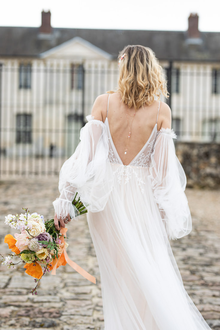 robe de mariee romantique avec bouquet de fleurs et collier de dos printanier